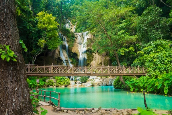 Standing on the bridge to admire the beauty of Kuang Si Waterfall 