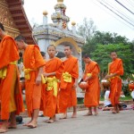 Monks receive food and flowers from local people
